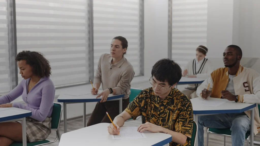 Candidats composant une épreuve écrite dans une salle d'examen